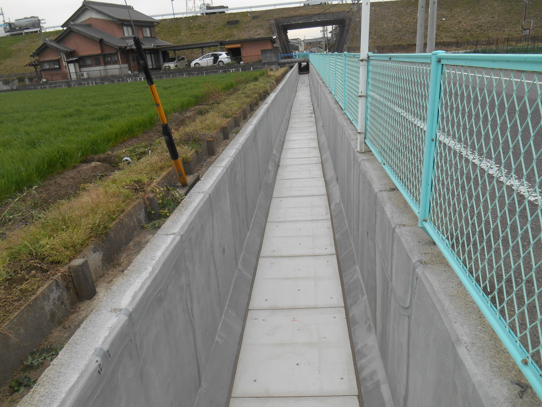 コンクリートで整備された水路と、その脇のフェンス