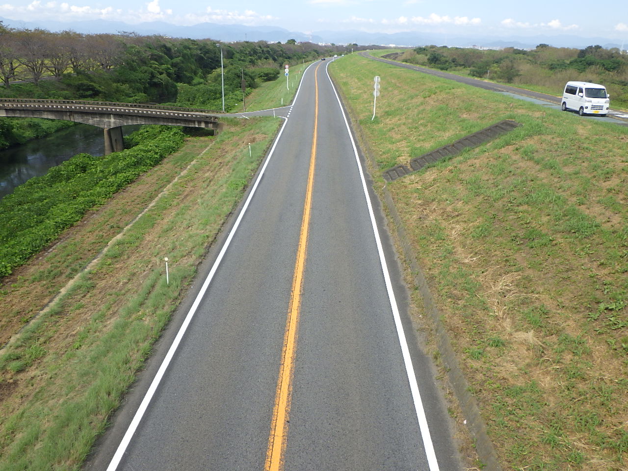 区画線が続く、緑に囲まれた道路